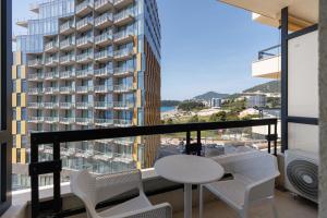 a balcony with a table and chairs and a building at Casa Al Mare Premium Residences in Rafailovici