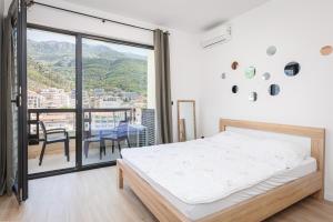 a bedroom with a bed and a balcony at Casa Al Mare Premium Residences in Rafailovici +67 photos
