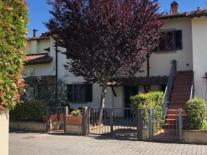 a tree in front of a house with a gate at Casa Varna in Gambassi Terme