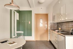 eine Küche mit einem weißen Tisch und einer weißen Arbeitsplatte in der Unterkunft The Nooq Lund - Hotel & Studios in Lund + 32 Fotos