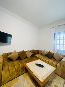 a living room with a brown couch and a table at Cocon alpin -studio bien équipé in Ifrane