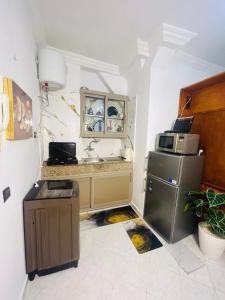 a kitchen with a refrigerator and a counter with a microwave at Cocon alpin -studio bien équipé in Ifrane