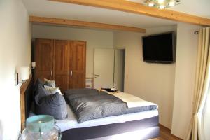 a bedroom with a bed and a flat screen tv at Ferienhaus Hartmut Löschke in Rheinsberg