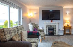 a living room with a couch and a fireplace at Skeabost View in Tole