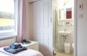 a bathroom with a bed and a sink and a mirror at Skeabost View in Tole +56 photos