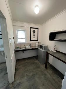 a kitchen with a sink and a microwave at Windpomp Guesthouse in Beaufort West +121 photos