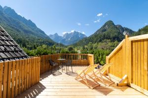 a wooden deck with a table and chairs on it at JASNA NATUR Resort by the lake in Kranjska Gora