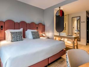 a bedroom with a large bed with a large headboard at Mercure Lugo Centro in Lugo