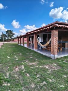 a brick building with a hammock outside of it at Solar do Ouro in São Thomé das Letras