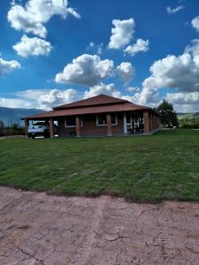 a house with a grass field in front of it at Solar do Ouro in São Thomé das Letras