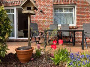 a patio with a table and a bird house at Ferienwohnung "Am Wichtelweg", 95176 in Rhauderfehn