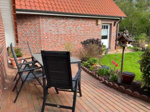 two chairs and a table on a patio at Ferienwohnung "Am Wichtelweg", 95176 in Rhauderfehn