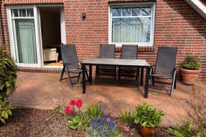 a table and chairs sitting on a brick patio at Ferienwohnung "Am Wichtelweg", 95176 in Rhauderfehn