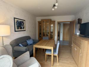 a living room with a table and a couch at Ferienwohnung "Am Wichtelweg", 95176 in Rhauderfehn +17 photos