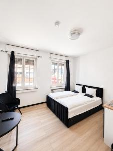 a bedroom with a large bed and a chair at FeWo- Room Rental Rheine in Rheine