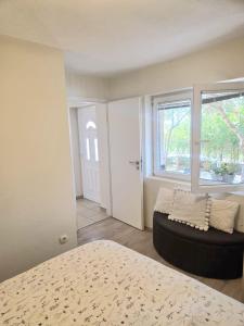 a bedroom with a bed and a couch and a window at Apartment Maro in Šibenik