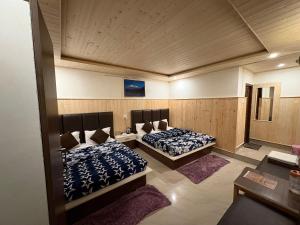 two beds in a room with two rugs at HOTEL MANISHA in Gangotri +29 photos
