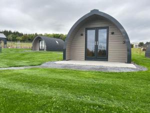 a small building in a field of green grass at Leahys Pod Park in Cork