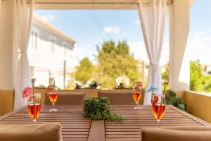 a wooden table with wine glasses on a balcony at Villa Sali ZadarVillas in Sali +45 photos