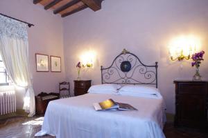 a bedroom with a bed with a book on it at Badia a Coltibuono Wine Resort in Gaiole in Chianti +80 photos