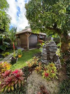 a garden with rocks and plants in front of a house at Studio Zen Caza Form -Option Spa Sauna au jardin in Le Lamentin