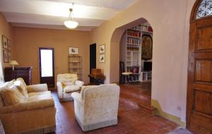 a living room with two chairs and an archway at Badia a Coltibuono Wine Resort in Gaiole in Chianti