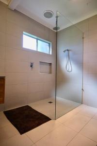 a shower with a glass door in a bathroom at White House Bendigo Garden Retreat in Epsom
