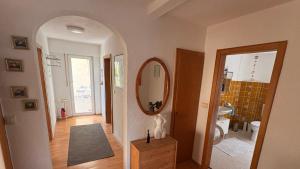 a hallway with a bathroom with a mirror and a sink at Apartment Hope Inn in Groß-Zimmern