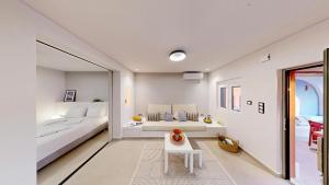 a white room with a bed and a table at Okto in Archangelos +54 photos