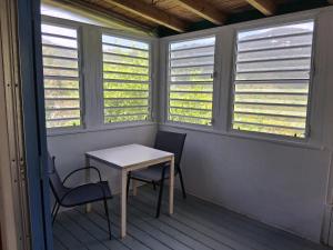 a porch with a table and chairs and windows at Neptunes Home in Saint John