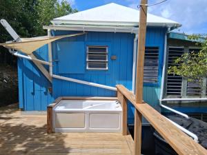 a blue house with a hot tub on a deck at Neptunes Home in Saint John +1 photo