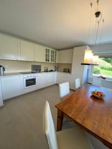a kitchen with a wooden table and white cabinets at Schönblick in Oberaichwald +23 photos