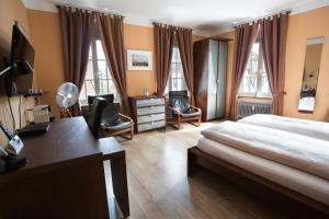 ein Schlafzimmer mit einem Bett und einem Schreibtisch und Stühlen in der Unterkunft Stadthotel Jülich in Jülich