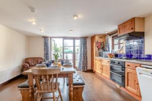 a kitchen with a wooden table and a dining room at 4 Bed in Westward Ho oc-n1623 in Westward Ho