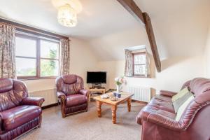 a living room with leather furniture and a tv at 4 Bed in Westward Ho oc-n1623 in Westward Ho