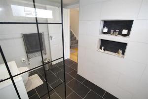 a bathroom with a glass shower and a toilet at 4 Bed in Swansea oc-hh682 in Parkmill +28 photos
