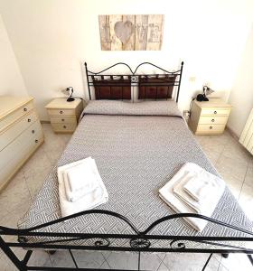 a bedroom with a large bed with two night stands at MARINE KISS- Appartamento con PARCHEGGIO PRIVATO GRATUITO- Vicino Porto Crociere e Stazione in Civitavecchia
