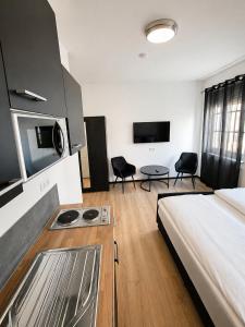 a room with a bed and a kitchen with chairs at FeWo- Room Rental Rheine in Rheine