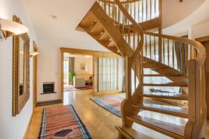 a wooden staircase in a home with a living room at Villa Schwarzbrunn in Stans +12 photos