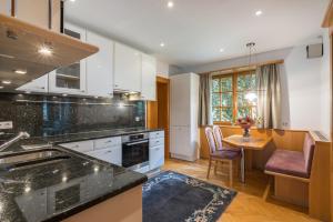 a kitchen with white cabinets and a table with a dining room at Villa Schwarzbrunn in Stans