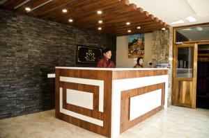 two people standing at a bar in a restaurant at Hotel Ugyen, Thimphu in Thimphu