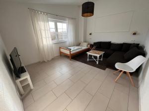 a living room with a black couch and a tv at Ferienwohnung Monteurwohnung in Wadern