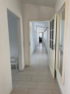 a hallway with white walls and a tile floor at Ferienwohnung Monteurwohnung in Wadern