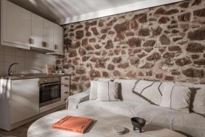 a living room with a couch and a stone wall at Ederlezi Boutique Hotel in Athens