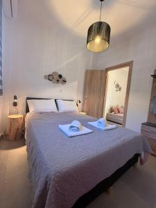 a bedroom with a large bed with towels on it at Averto House Lefkada in Lefkada