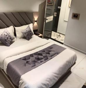 a bedroom with a large bed and a mirror at Hotel Bellemount in Ahmedabad +8 photos