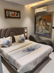 a bedroom with two beds with a large picture on the wall at Hotel Bellemount in Ahmedabad