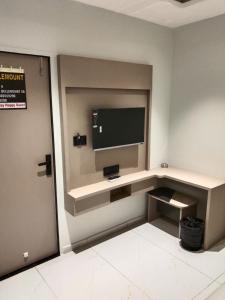 a room with a flat screen tv on a wall at Hotel Bellemount in Ahmedabad