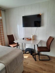 a room with a table and a tv on a wall at Augsburg!Möblierte Appartment! in Augsburg