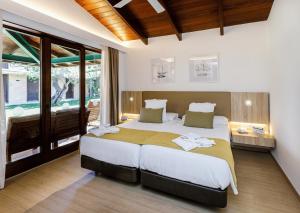 a bedroom with a large bed and a large window at PortBlue Club Pollentia Resort & Spa in Alcudia +95 photos